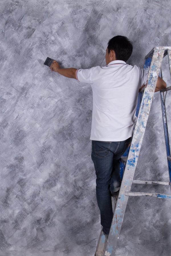 worker use brush for color paint concrete Loft style on wall of house